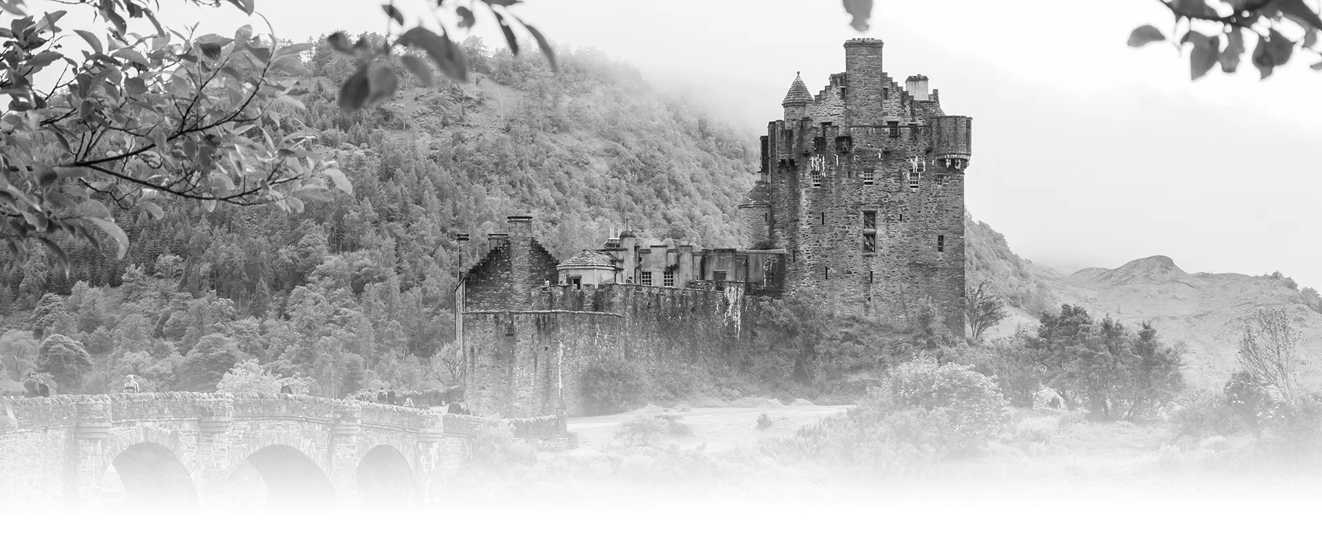 Historic stone castle in the Scottish Highlands surrounded by green hills and water