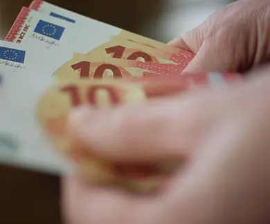 Hand counting euro banknotes as a symbol of tangible currency