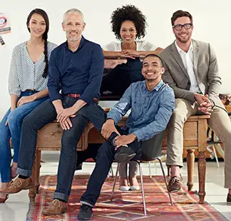 Diverse team of five professionals smiling in a creative studio workspace