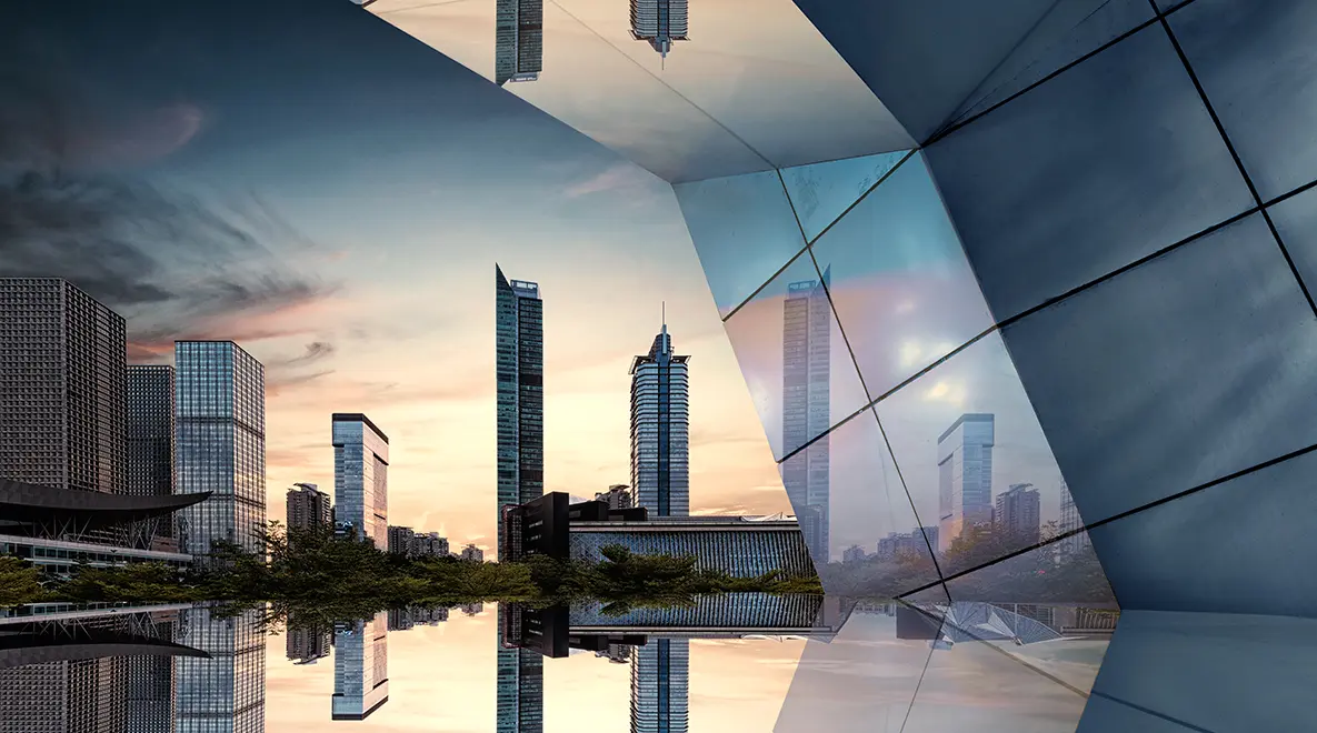 Futuristic cityscape with mirrored reflections and geometric architecture at sunset